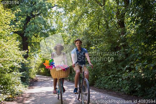 Image of Young multiethnic couple having a bike ride in nature