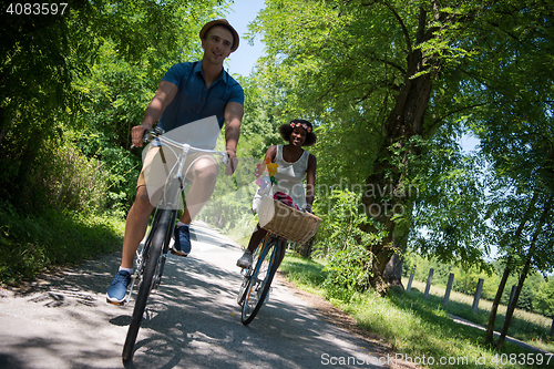 Image of Young multiethnic couple having a bike ride in nature