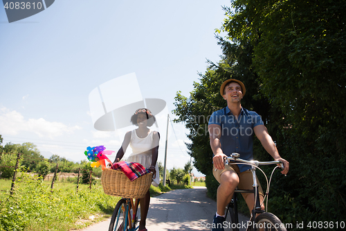 Image of Young multiethnic couple having a bike ride in nature