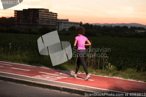Image of a young African American woman jogging outdoors