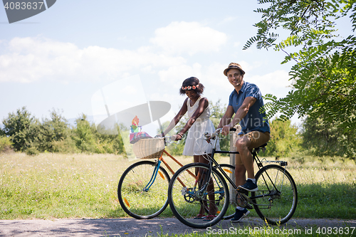 Image of Young multiethnic couple having a bike ride in nature