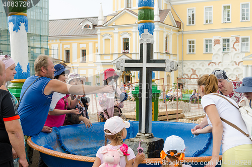 Image of Sergiev Posad - August 10, 2015: Tourists are gaining the holy water in the passage of the bowl with a cross in Svvyato Trinity St. Sergius Lavra