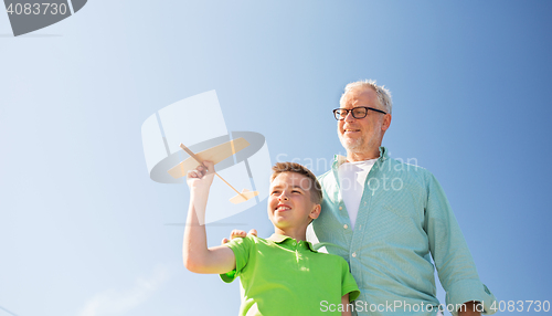 Image of senior man and boy with toy airplane over sky
