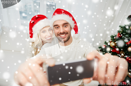 Image of couple taking selfie with smartphone at christmas