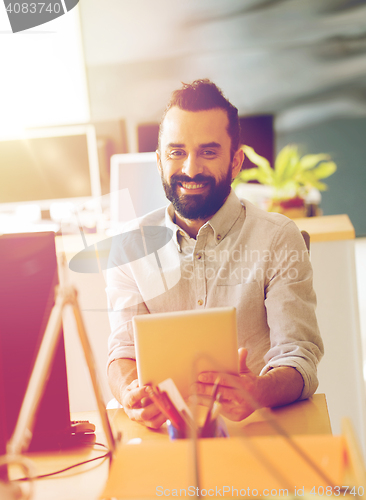 Image of happy creative male office worker with tablet pc