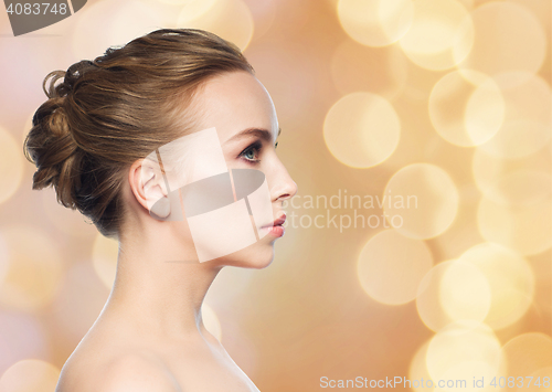 Image of beautiful young woman face over holidays lights