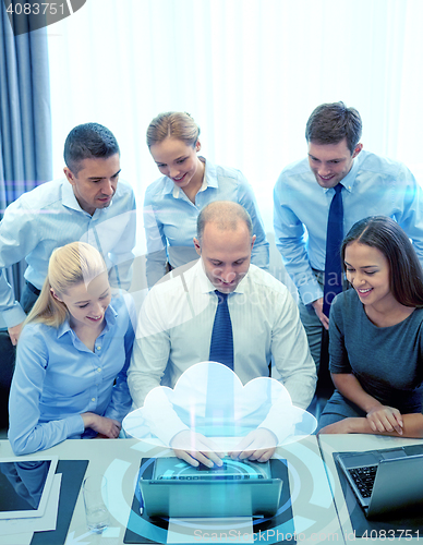 Image of smiling business people with laptop in office