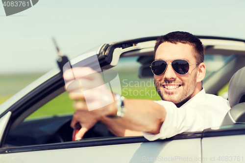 Image of happy man in cabriolet showing car key