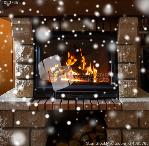 Image of close up of burning fireplace with snow