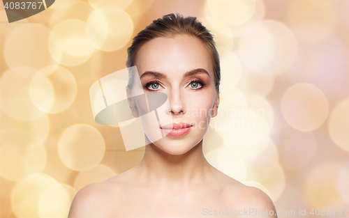 Image of beautiful young woman face over holidays lights