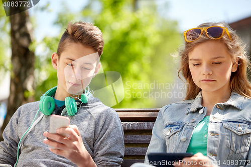 Image of teenage friends with gadgets outdoors