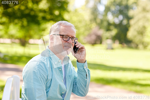 Image of senior man calling on smartphone at summer park