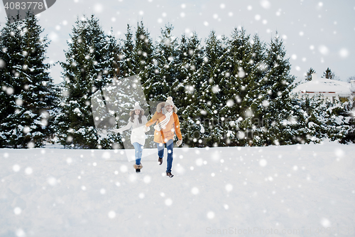 Image of happy couple running in winter snow
