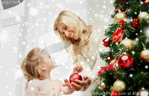 Image of happy family decorating christmas tree at home