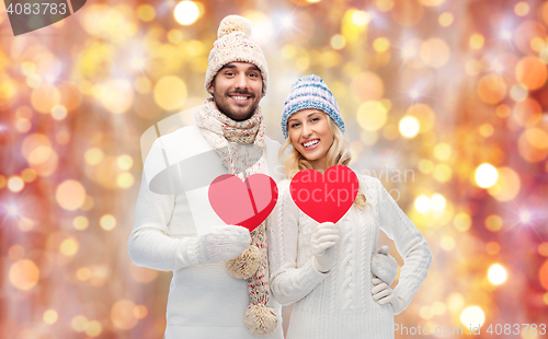 Image of smiling couple in winter clothes with red hearts