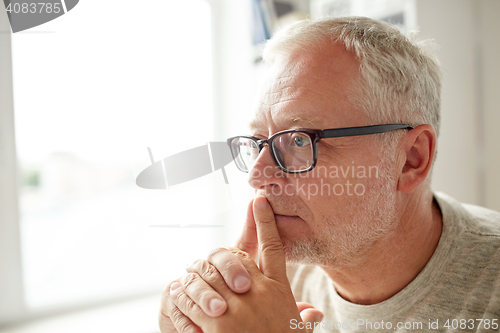 Image of close up of senior man in glasses thinking