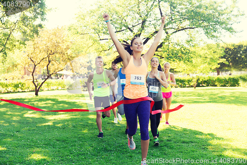 Image of happy young female runner winning on race finish