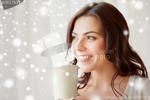 Image of happy woman with cup of tea or coffee at home