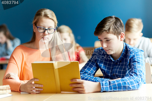 Image of students reading book at school lesson