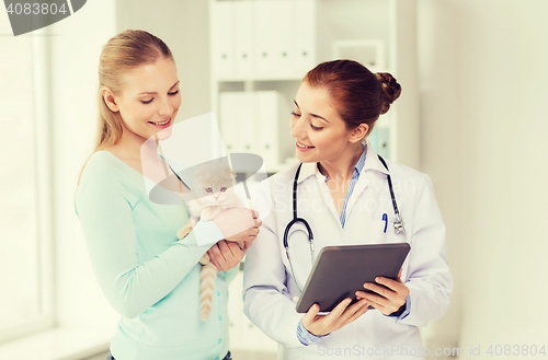 Image of happy woman with cat and doctor at vet clinic