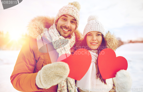 Image of happy couple with red hearts over winter landscape