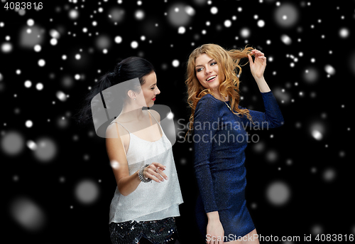 Image of happy young women dancing over snow