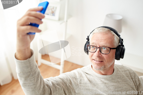 Image of senior man with smartphone and headphones