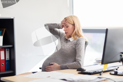 Image of pregnant businesswoman feeling sick at office work