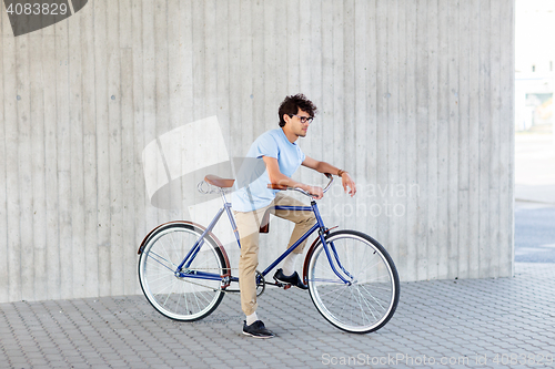 Image of young hipster man riding fixed gear bike