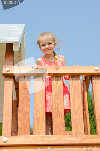 Image of Happy little girl in a pink dress on playground