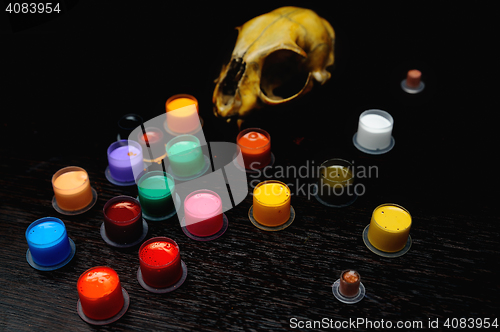 Image of Caps for tattoo ink with colored  on the background of a skull.