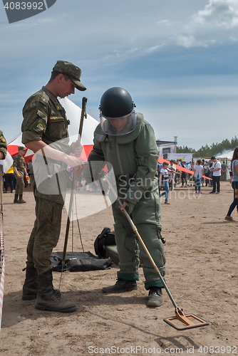 Image of Man - visitor of show tries on the sapper suit