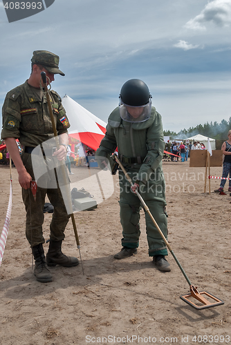 Image of Man - visitor of show tries on the sapper suit