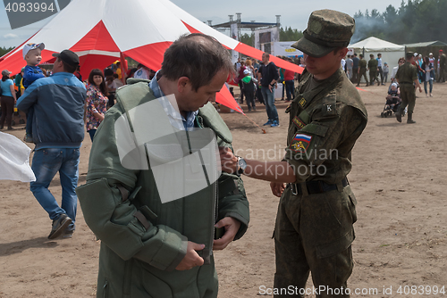 Image of Man - visitor of show tries on the sapper suit