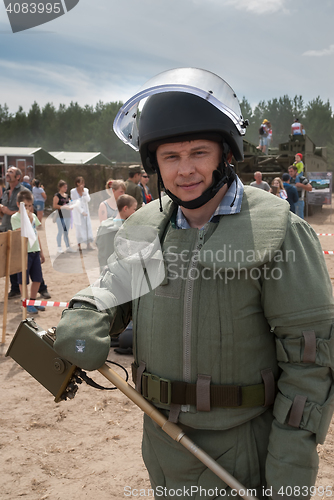 Image of Man - visitor of show tries on the sapper suit