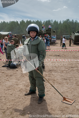 Image of Man - visitor of show tries on the sapper suit