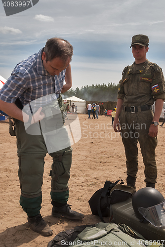Image of Man - visitor of show tries on the sapper suit