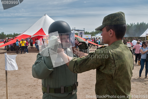 Image of Man - visitor of show tries on the sapper suit