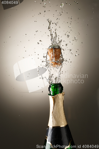 Image of Champagne bottle with cork popping and splash