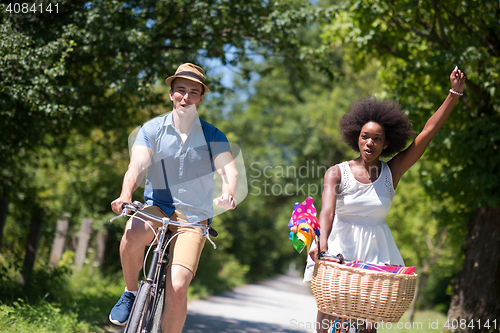 Image of Young multiethnic couple having a bike ride in nature