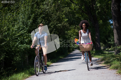 Image of Young multiethnic couple having a bike ride in nature