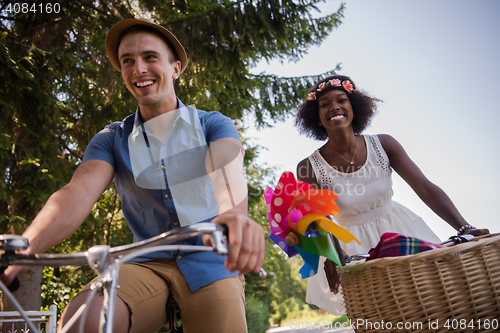 Image of Young multiethnic couple having a bike ride in nature