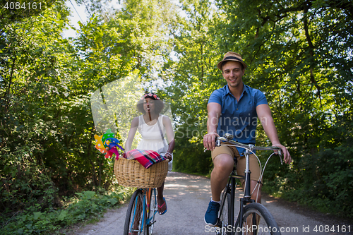 Image of Young multiethnic couple having a bike ride in nature