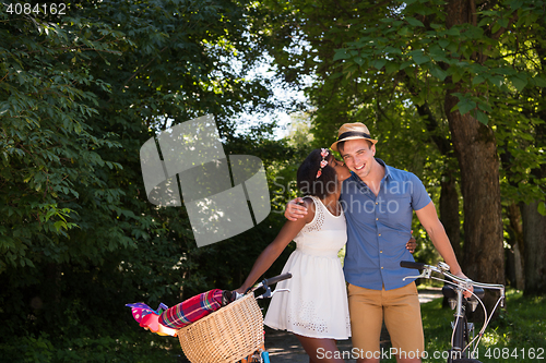 Image of Young multiethnic couple having a bike ride in nature