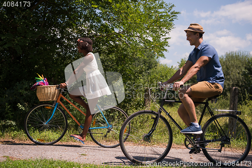 Image of Young multiethnic couple having a bike ride in nature