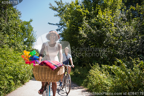 Image of Young multiethnic couple having a bike ride in nature