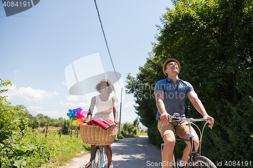 Image of Young multiethnic couple having a bike ride in nature