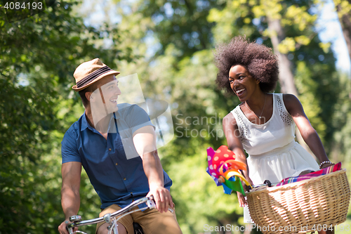 Image of Young multiethnic couple having a bike ride in nature