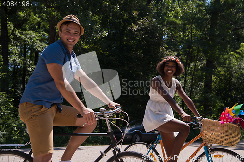 Image of Young multiethnic couple having a bike ride in nature