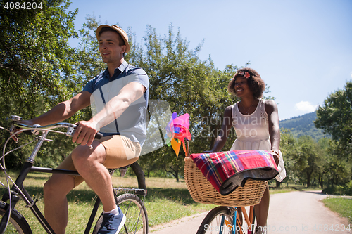 Image of Young multiethnic couple having a bike ride in nature